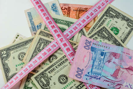 Heap of money and measuring tape on a white background. Money dollars concept.One dollar.の写真素材