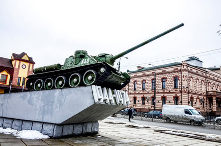 City of Rivne. Ukraine. March, 2021.Old military tank SU-100 from World War 2 on city street. Monument to Liberating Soldiers by blue sky in Rivne, Ukraineのeditorial素材