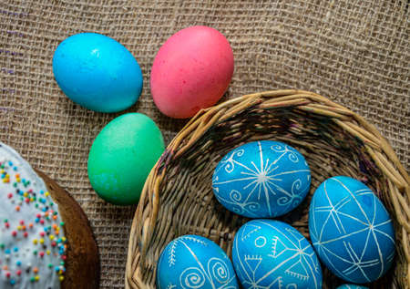 Three handmade Easter eggs decorated with wax-resist dyeing technique. Ukrainian pysanka on white shabby wooden background with empty space for textの写真素材