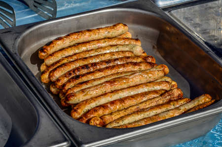 Grilled sausages, homemade, cast iron skillet or frying pan with tomatoes, garlic and rosemary. brazilian barbecue.の写真素材