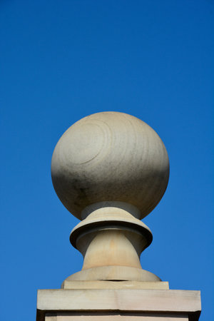 Stone ball final on pedestal. Traditional post topper or post cap .Large stone ball of gray color on the pedestal .の写真素材