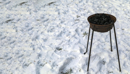 Burning Charcoal in a Grill .Natural charcoal in an adapted metal bowl for outdoor heating in winter.の写真素材