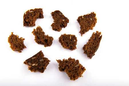 pieces and crumbs of a multigrain toast. soft crumbs of dark bread stand out against a white background, top view.の写真素材