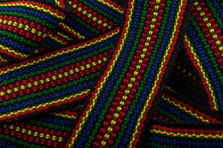 A traditional Ukrainian belt woven from woolen threads.A bright element of folk costume. The belt is on a white background.の写真素材