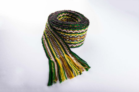 A traditional Ukrainian belt woven from woolen threads.A bright element of folk costume. The belt is on a white background.の写真素材