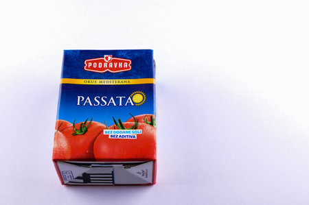 Lviv.Ukraine. December 11, 2023.One container with passed tomatoes. Tomato sauce. White background.disposable portioned packaging of tomato paste.のeditorial素材