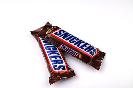 Lviv, Ukraine. January 29, 2024.Editorial illustrative image of snickers chocolate bar with peanuts, caramel and nougat closed up isolated on whiteのeditorial素材