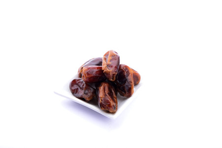 Bowl with dried dates isolated on white background.Fresh dried dates on white background.Plate with...