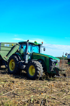 Lviv, Ukraine. September 17, 2023.Close-up of a large green tractor with a trailer loaded with...