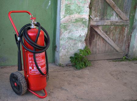 Large mobile red powder fire extinguisher on trolley wheels. Fire protection equipmentのeditorial素材
