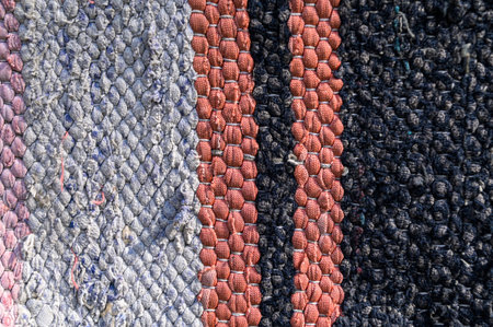Traditional rustic carpet with a striped pattern.Background of multi-colored homespun rug....