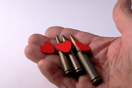 A bullet and a heart in one hand.The power of men in war and in peace.