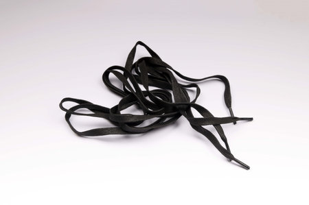 new long black shoe laces on a white backgroundの写真素材