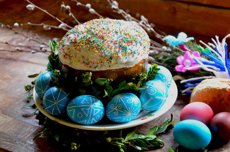 A photorealistic close-up of freshly baked Easter pastries: tall glazed cakes, golden buns, and...