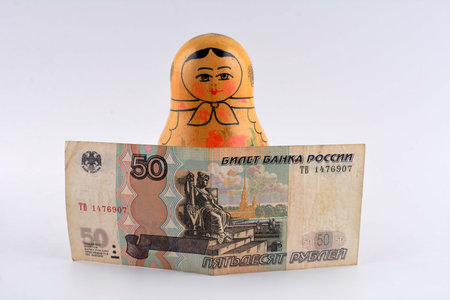 Russian Rubles (RU) currency banknote and coin in tourism concept with Russian nesting dolls as...
