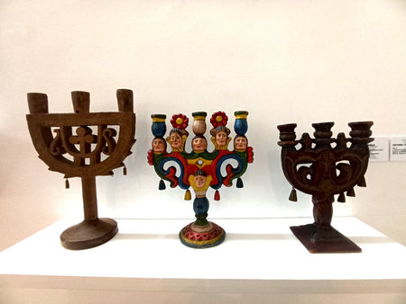 Lviv, Ukraine. January 22, 2026.Traditional wooden triple candle holders typical of Galicia. Examples of folk sacred art with carving and polychrome decoration displayed in a museum exhibition.のeditorial素材