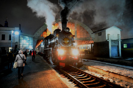 Lviv, Ukraine. February 14, 2026.Vintage steam locomotive with thick smoke at the railway station in...