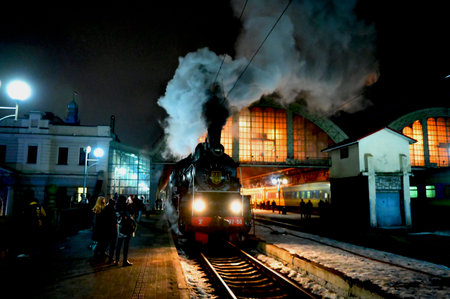 Lviv, Ukraine. February 14, 2026.Vintage steam locomotive with thick smoke at the railway station in...