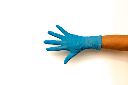 Female hand in a colored rubber glove. Isolate on white background. The concept of the work of a cook in a restaurant or a doctorの写真素材