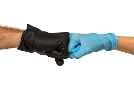 man and a woman in multi-colored rubber gloves shake hands with each other. Isolate on a faded...