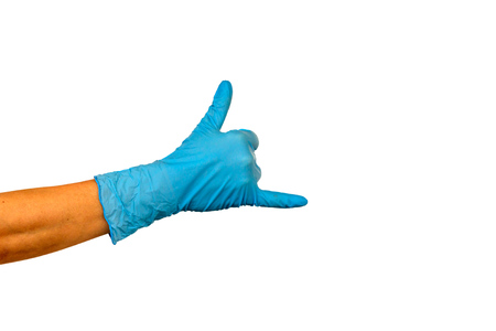 Isolate  hand showing two fingers in a blue rubber glove on a white background. Gesture that rocks or horns. The concept of successful work of a chef of a surgeon or cleaningの写真素材