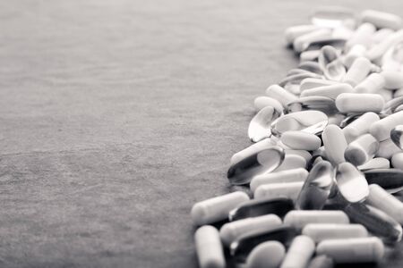 Tablets, pills, capsules, drugs pouring out of white bottle on white background. Sport, healthy lifestyle, medicine, nutritional supplements, people concept - closeup fish oil capsules softgelの写真素材