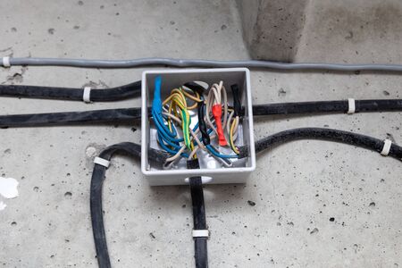 Cable laying ceiling. Electrical wires on wall. Wiring replacement. Connecting light in flat or office. Professional installation bulb, electrical outlet, cables, wires, switches. Insulationの写真素材