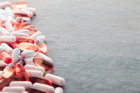 Tablets, pills, capsules, drugs pouring out of white bottle on white background. Sport, healthy...