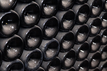 Closeup pattern from bottom of old dark dusty wine bottles in rows in cellar, basement, wine warehouse, winery. Concept vault with old rare wines, exclusive collection rare bottle. Mosaic backgroundの写真素材