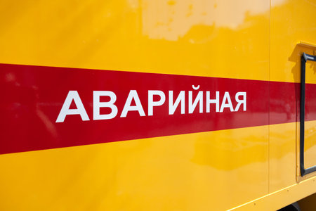 Russia Moscow 2019-06-17 Closeup side of yellow emergency service vehicle with a horizontal red...