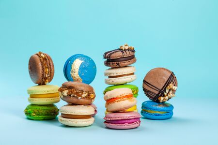 Different types of colorful sweet macaroons dessert on blue backgroundの写真素材