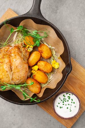 Baked tobacco chicken with potatoes, sour cream, herbs in panの写真素材