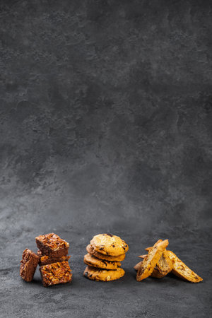 Sweet crispy nugatin biscotti cookies on dark surface