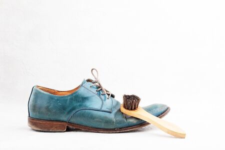 Pair of old leather blue boots with laces with shoe brushの写真素材