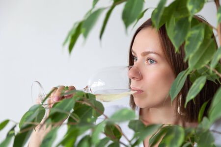 Caucasian brunette girl sommelier drinking white wine from glassの写真素材