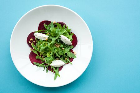Vegetable salad of fresh beets, arugula, cottage cheese, pine nutsの写真素材