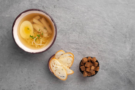 Chicken broth soup with egg, noodle, chicken meat fillet