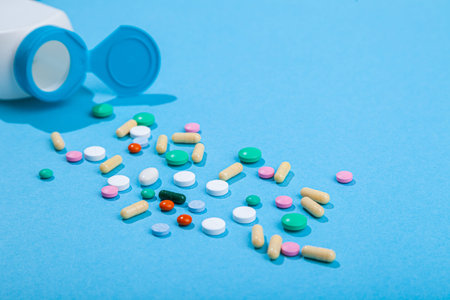 Top view of assorted scattered from pill bottle colorful tablets and capsules