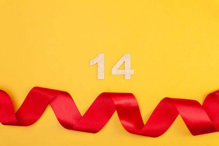 Beautiful red heart and curved ribbon on yellow background