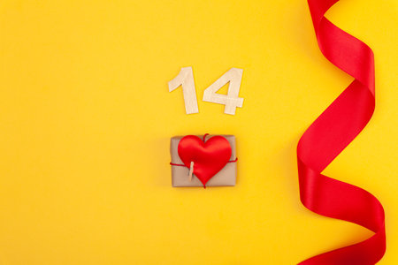 Beautiful red heart and curved ribbon on yellow backgroundの写真素材