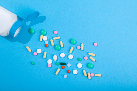 Top view of assorted scattered from pill bottle colorful tablets and capsules