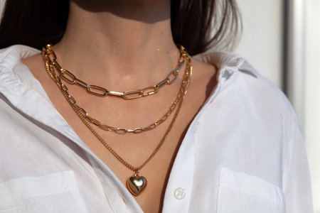 Beautiful model brunette in modern gold metal necklace chain