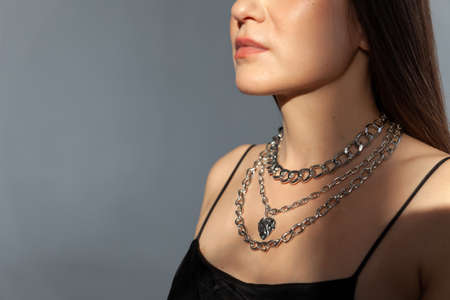 Beautiful model brunette in modern silver metal necklace, many chainsの写真素材