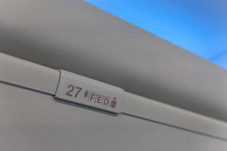 Sign of seat number with number and letter on luggage shell inside passenger airplaneの写真素材