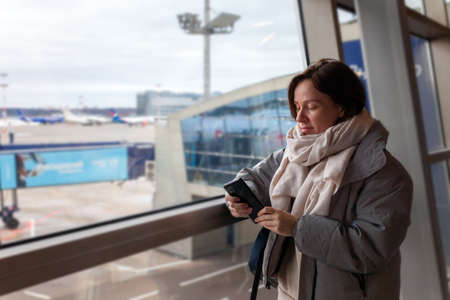 Girl tourist with backpack waiting for flight in airport, horizontalの写真素材