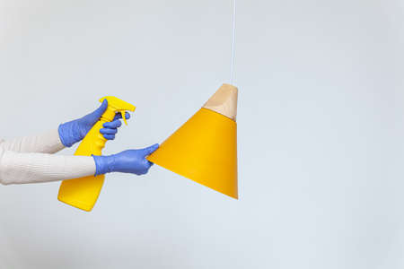 Hands in gloves removing dust, cleaning electric lamp, chandelierの写真素材