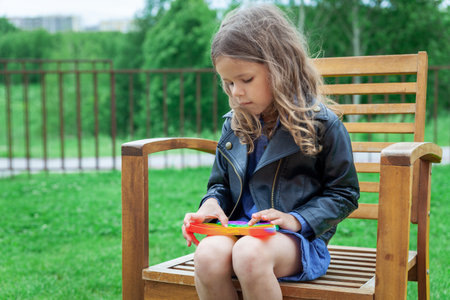 Caucasian little girl playing with pop silicone trendy rainbow color toyの写真素材