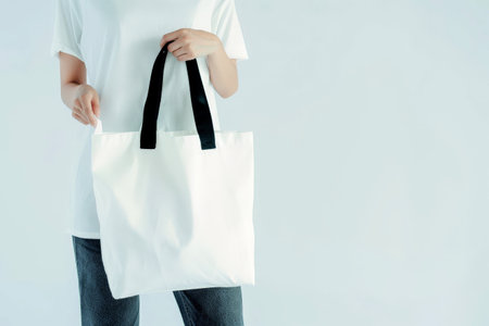 woman Hand holding a White Polyester square tote bag for mockup . AI generated image.の素材