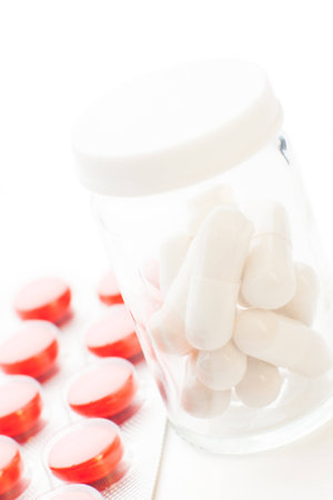 Tablets and bottle of pills isolated on whiteの写真素材