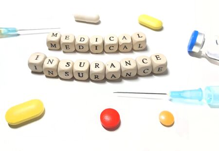 Medical insurance is laid out from wooden cubes. Ambulance, medicines, pills.の写真素材